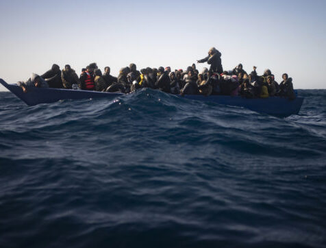 Migrants from Eritrea, Egypt, Syria and Sudan, wait to be assisted by aid workers of the Spanish NGO Open Arms, after fleeing Libya on board a precarious wooden boat in the Mediterranean sea, about 110 miles north of Libya, on Saturday, Jan. 2, 2021. (AP Photo/Joan Mateu)